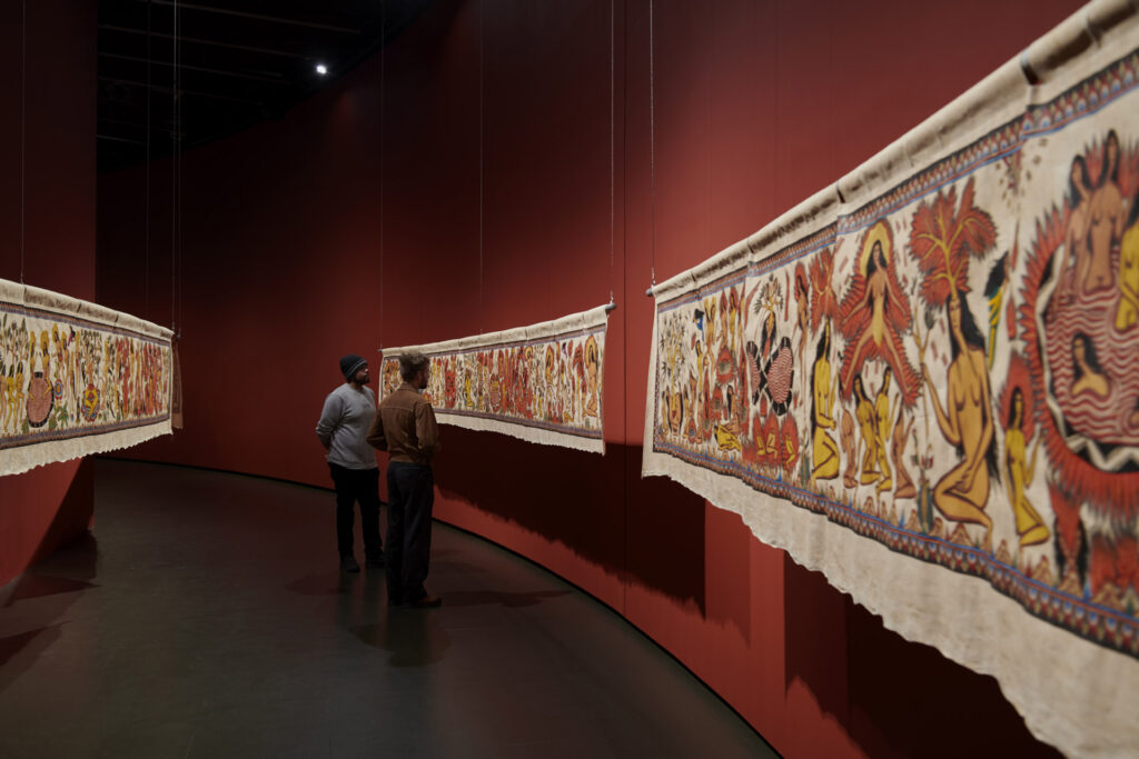 Citra Sasmita, ‘Act Two’ of ‘Into Eternal Land’, 2024, ac rylic on python skin, artificial hair, and found wooden carved mask, dimensions variable. Image by Jo Underhill / Barbican