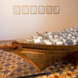 Ahmad Abu Bakar, 'Telok Blangah', 2013, installation with paint varnish, glass bottles, decals traditional wooden boat, 300 x 450 cm. Image from Artsy