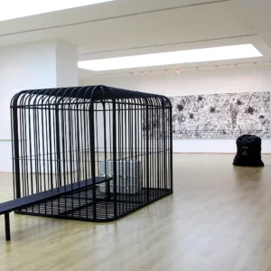 H.H.Lim-‘The Cage, the Bench and the Luggage’-2011-2017-iron cage-bench-and luggage-484x216x228cm-Image-from-Tang-Contemporary.jpeg